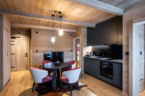 a kitchen with a black table and chairs at Swissôtel Resort Kolasin in Kolašin
