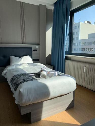 a large bed in a room with a large window at Mooncity Hotel & Boardinghouse in Frankfurt