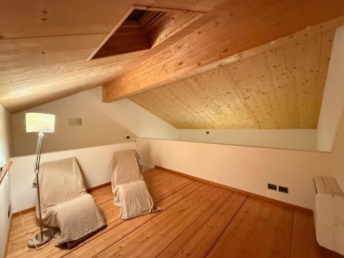 two chairs in an attic room with wooden floors at Marco Polo in Vittorio Veneto