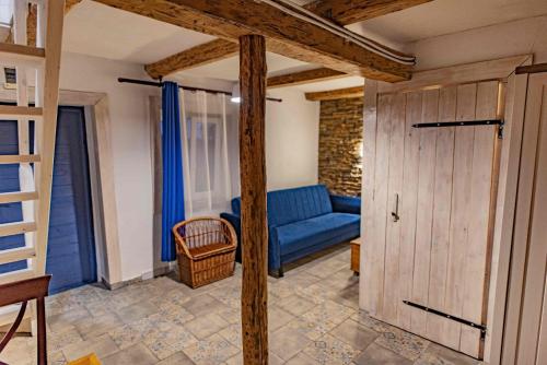 a living room with a blue couch and a wooden door at Apartamenty Folwark Malinowy Chruśniak in Bisztynek
