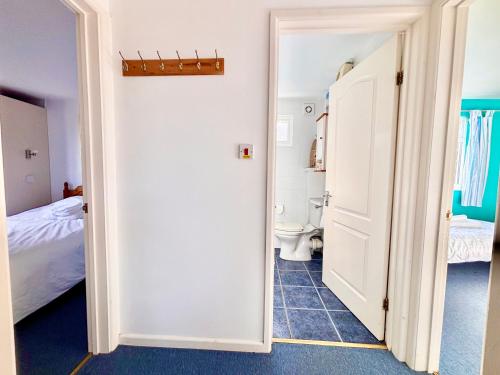 a bathroom with a bed and a toilet in a room at Trevone - Chalet 130 in Padstow