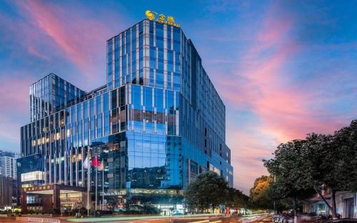 a tall glass building with a sign on top of it at Kunming Golden Eagle Summit Hotel in Kunming