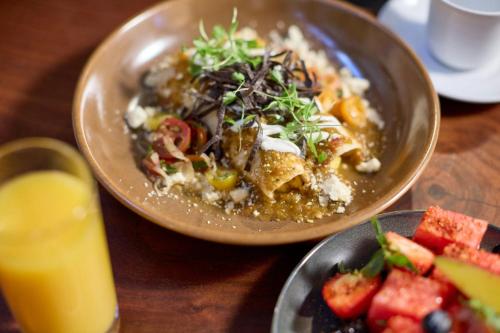 uma mesa com duas tigelas de comida e um prato de frutas em The Worthington Renaissance Fort Worth Hotel em Fort Worth