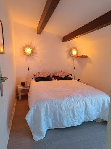 - une chambre avec un lit et deux lumières sur le mur dans l'établissement Cap Pinède jardin, au Cap d'Agde