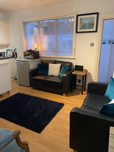 a living room with a couch and a table at London Zone 2, Private, Cosy accommodation near Canary Wharf in London