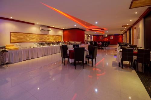 a restaurant with tables and chairs in a room at Rose Oasis Hotel in Najran