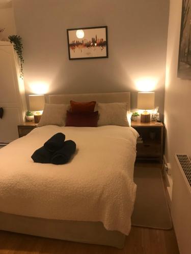 a bedroom with a large white bed with two lamps at London Zone 2, Private, Cosy accommodation near Canary Wharf in London