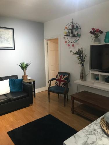 a living room with a couch and a tv at London Zone 2, Private, Cosy accommodation near Canary Wharf in London