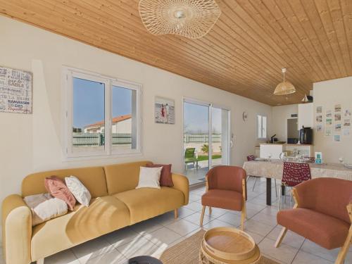 un salon avec un canapé et une table dans l'établissement Jolie maison avec extérieur pour 6 proche mer, à Saint-Hilaire-de-Riez