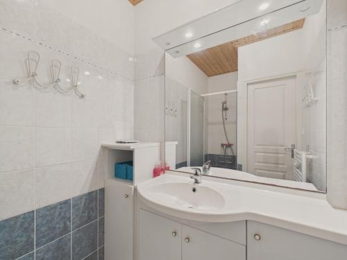 une salle de bain blanche avec un lavabo et un miroir dans l'établissement Jolie maison avec extérieur pour 6 proche mer, à Saint-Hilaire-de-Riez