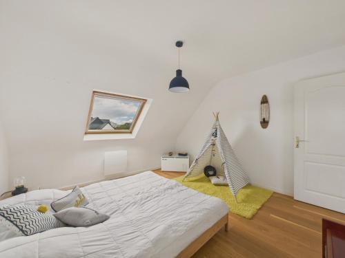 - une chambre avec un lit et une maison pour chats dans l'établissement Maison avec terrasse et jardin pour 6 - Bénodet, à Bénodet