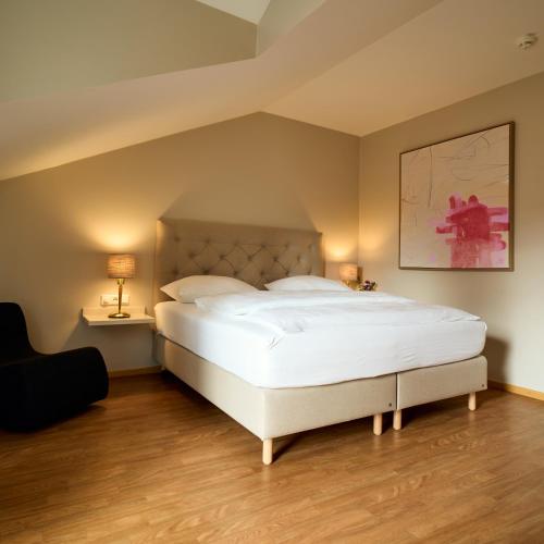a bedroom with a large white bed and two lamps at Hotel Engbert in Oelde