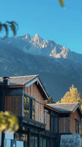 a house with a mountain in the background at The Rock Hotel in Lijiang