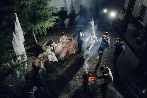 a group of people walking around a park at night at The Rock Hotel in Lijiang