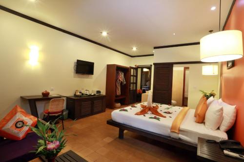 a bedroom with a bed and a desk in a room at Residence Indochine D'angkor in Siem Reap