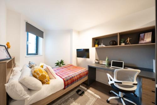 a bedroom with a bed and a desk and a chair at Canvas Wembley in London in London