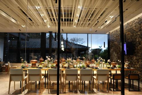 a large dining room with a long table and chairs at The Rock Hotel in Lijiang
