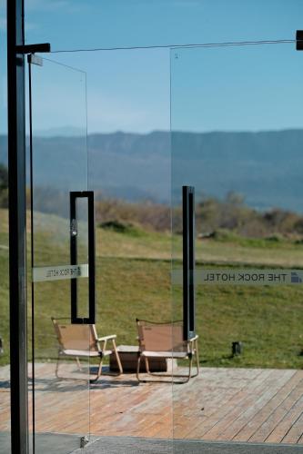 two chairs sitting in front of a glass window at The Rock Hotel in Lijiang