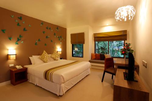1 dormitorio con 1 cama grande con pájaros en la pared en The Viridian Resort - SHA Plus, en Patong Beach