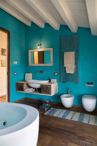 a blue bathroom with two sinks and a tub at Ca' del Buso Cottage in Montecchio