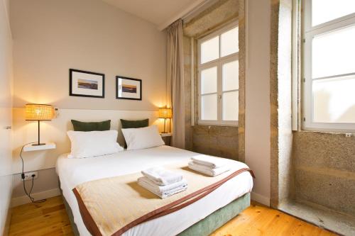 a bedroom with a bed with towels on it at RVA - Porto Central Flats in Porto