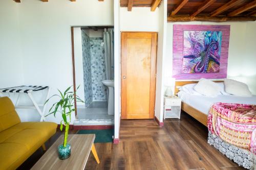 a room with a bed and a couch and a table at Cristal Blue Barú in Baru