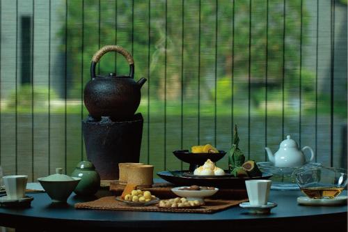 Příslušenství pro přípravu čaje a kávy v ubytování Yixing Yuzizai Bamboo Sea Resort