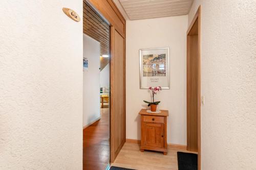 a hallway with a door and a table with flowers on it at Drei Tannen in Todtnau