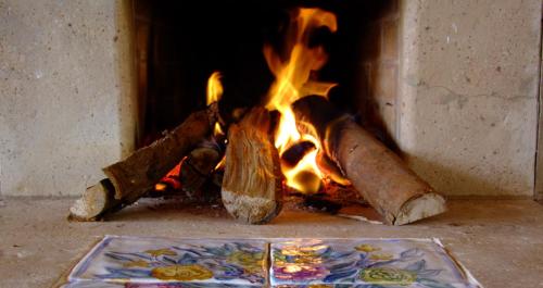a fireplace with a fire burning inside of it at Lis Bleu Pousada in Tiradentes