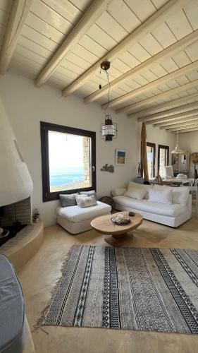 a living room with two white couches and a table at Holiday House - Koundouros Panoramic Sea View in Koundouros