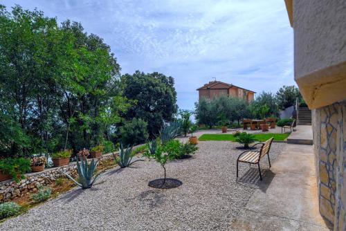 a courtyard with a chair and plants and a building at House ALANIS wtih sea view in quiet location in Ravni