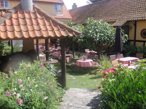 a garden with a gazebo and tables and chairs at Hotel Klostergaarden in Allinge