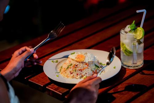 a table with a plate of food and a drink at Hotel Sanjana & Restaurant in Polonnaruwa