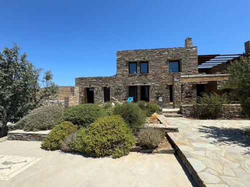 a brick house with some bushes in front of it at Holiday House - Koundouros Panoramic Sea View in Koundouros