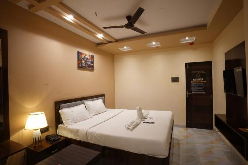 a bedroom with a bed with a ceiling fan at Hotel Blissful in Thane