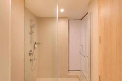 a shower with a glass door in a bathroom at Keys Select by Lemon Tree Hotels, Hosur Road, Bengaluru in Bengaluru