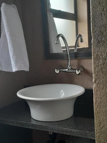 a white sink in a bathroom with a mirror at African Bushveld 129A 1 x Bachelor Unit in Buffelspoort