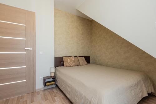 a small bedroom with a bed and a staircase at Vila Dia Palanga in Palanga