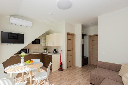a living room and kitchen with a table and chairs at Vila Dia Palanga in Palanga