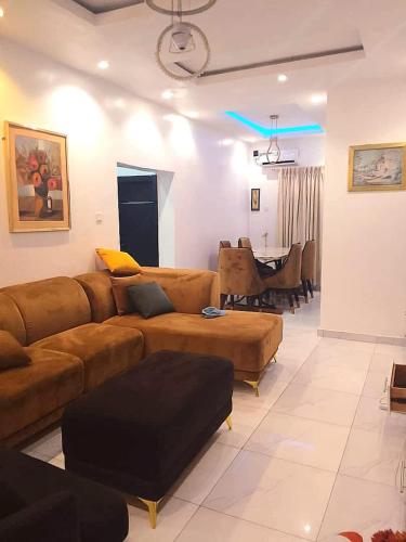 a living room with a couch and a dining room at Monica's Place - One bedroom Lekki Flat in Ikota