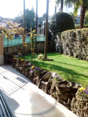 a garden with flowers on a rock wall at Casa Lari Stresa in Stresa