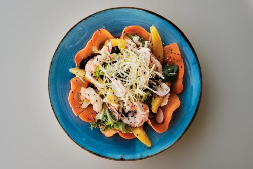 a blue plate of food with shrimp and vegetables at Prinsotel Alba & Spa in Cala d´Or