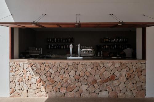 a bar with a stone wall behind it at Prinsotel Alba & Spa in Cala d´Or