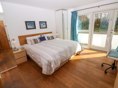 a bedroom with a large bed and a window at Gwelfor, Marloes in Haverfordwest