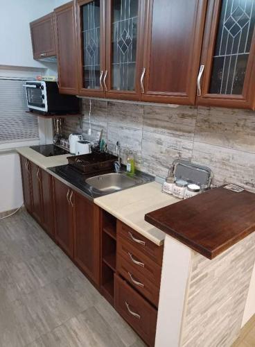 a kitchen with wooden cabinets and a sink at Vila Dzavric in Zlatibor