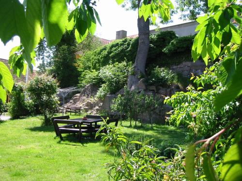 a park with a picnic table and a tree at Hotel Klostergaarden in Allinge
