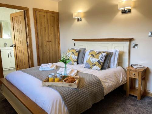 a bedroom with a bed with a tray of food on it at Pwyll Holiday Cottage in Pentraeth