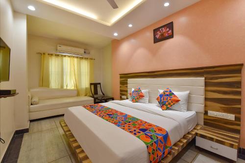 Un dormitorio con una cama grande y un sofá. en FabHotel The Wind Palace, en Jaipur
