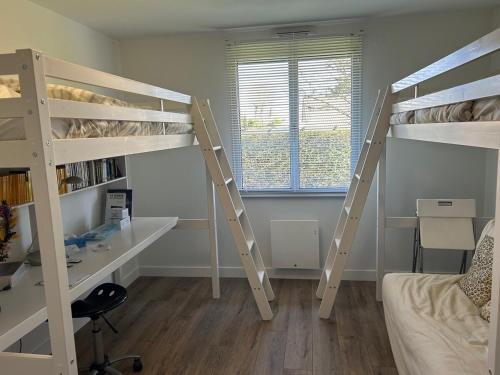 une chambre avec deux lits superposés et un bureau dans l'établissement Maison familiale avec piscine, à La Teste-de-Buch