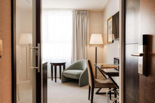 a hotel room with a chair and a desk at Grand Hotel Casselbergh in Bruges